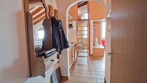 A narrow hallway with wooden doors and a coat rack. - Studio Riffelsee (Zermatt)
