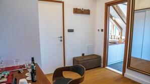 A room with a wooden dining table set with wine glasses and a bottle, a cushioned bench, and a door leading to a balcony with a view. - Oblivion rooms (Split)