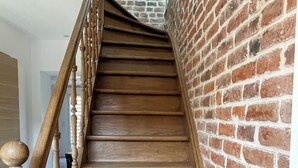 A wooden staircase with a brick wall on one side. - Maison Familiale Avec Jardin (Avelin)