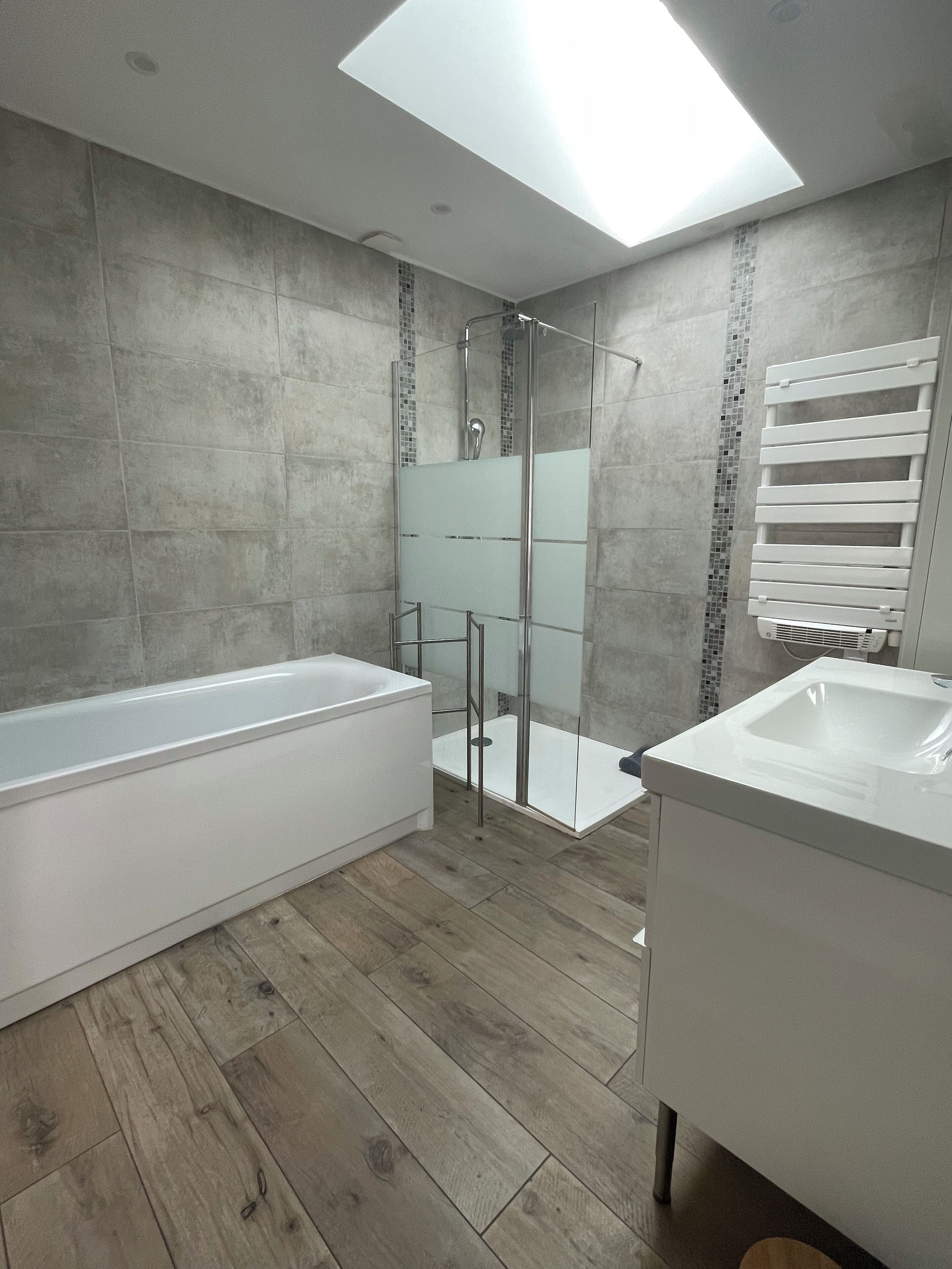 Une salle de bain moderne dotée d’une douche à parois de verre, d’une baignoire sur pieds et d’un meuble-lavabo.