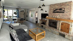 A spacious living area with a fireplace, a sofa, and a coffee table. - Maison Familiale Avec Jardin (Avelin)