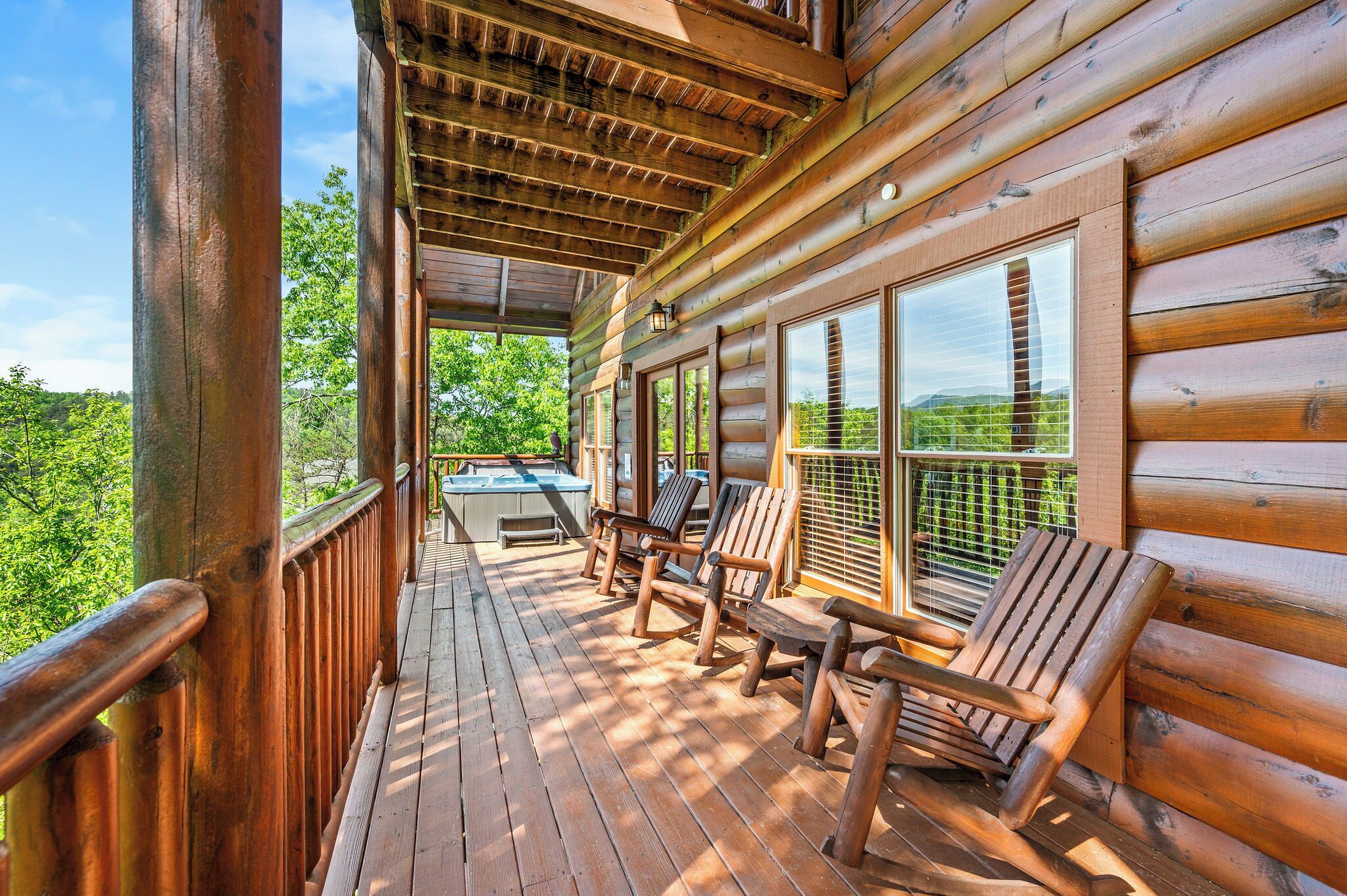 A wooden deck with outdoor seating and a view of the landscape.