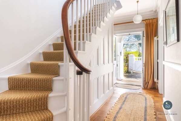 A staircase with patterned carpet, white railings, and a wooden handrail. - Nothe House - Exclusive home, Weymouth Harbour (Weymouth)