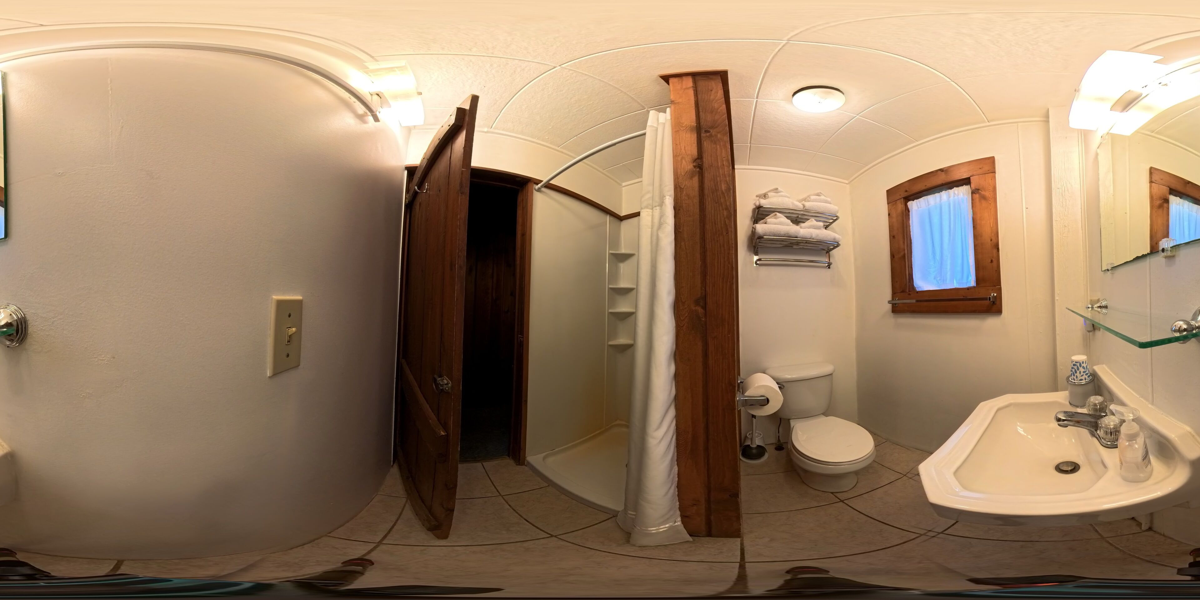 A bathroom with a toilet, sink, and shower area.