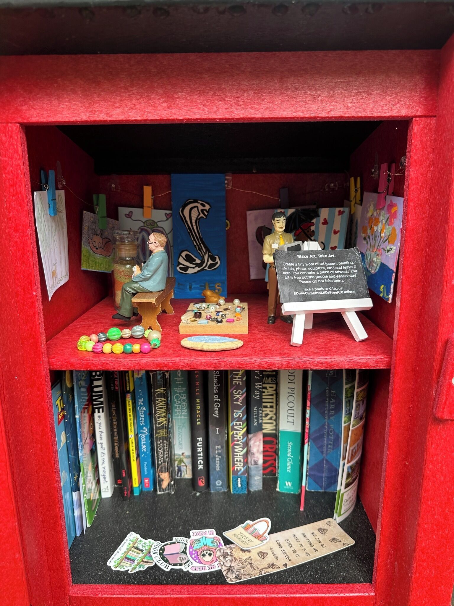 A bookshelf with various books, a small easel with a sign, and decorative items.