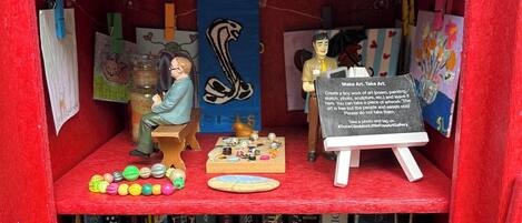 A bookshelf with various books, a small easel with a sign, and decorative items.