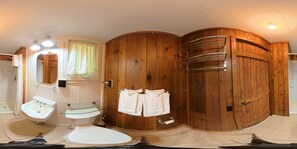Un baño con lavamanos con cerramiento de vidrio, tocador con pedestal, inodoro y zona de ducha.