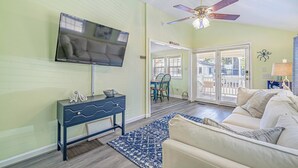 A living room with a TV, a ceiling fan, a sofa, and a dining area with a table and chairs. - 1654 Ocean Lakes Pet Friendly Golf Cart⛱️🏝️🩱🌊👙☀️🐚 (Myrtle Beach)