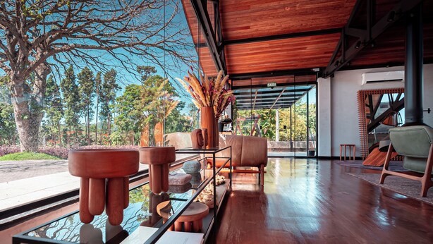 A spacious room with a wooden floor, a large window overlooking a garden, and a modern interior design. - NOR HOTEL & SPA (Sao Roque)