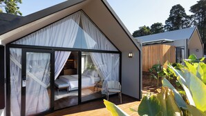 A modern bedroom with a glass door, a bed, and a chair. - NOR HOTEL & SPA (Sao Roque)