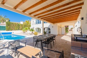 Enjoy al fresco dining on the patio, surrounded by lush greenery and a serene pool.