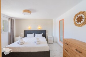 Restful retreat with a large bed, two bedside tables, and a dresser.