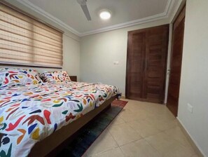 Cozy retreat with a single bed, ceiling fan, and light fixture.