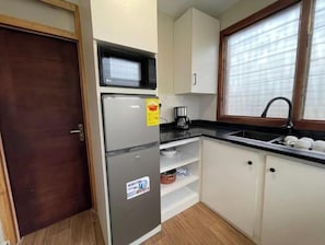 Kitchen area with refrigerator, microwave, and coffee maker.