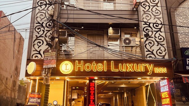 Un immeuble à plusieurs étages, sur lequel on peut voir une grande enseigne indiquant « Hôtel de luxe ».