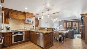 Una cocina amplia con armarios de madera, electrodomésticos de acero inoxidable y una isla central.