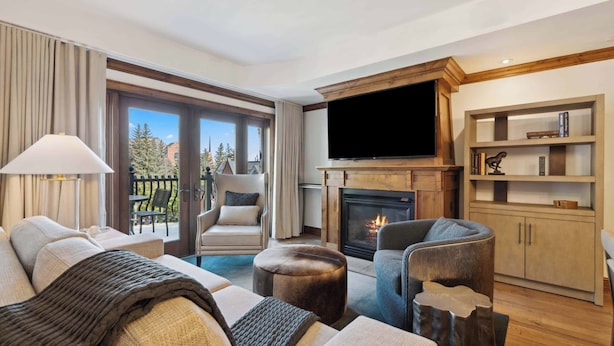 Una sala de estar moderna con chimenea, televisor de pantalla plana y estantería.