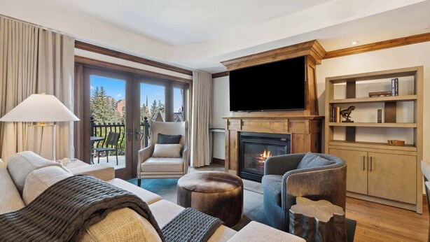 Un salon moderne doté d’une cheminée, d’un téléviseur à écran plat et d’une bibliothèque.