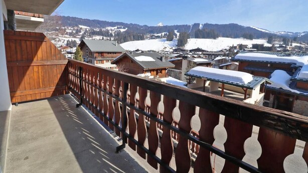 A balcony with a view of a snow-covered village and mountains. - 1st floor, balcony, tv, 45m², Les Gets (Les Gets)