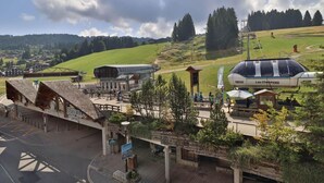 A ski resort with a chairlift, parking area, and buildings with signage for 'Les Charrons'.