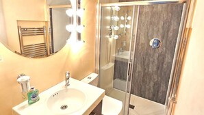 Ein modernes Badezimmer mit Waschtisch, Spiegel und Dusche.