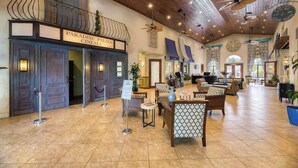 A spacious lobby with a cinema, wooden ceiling, and a reception desk. - Disney Retreat: Pool, Themed Rooms, Pets Welcome! (Kissimmee)