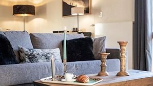 Un accogliente soggiorno con un tavolino in legno, un divano grigio e un quadro appeso al muro.