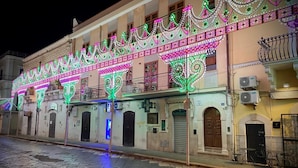 A building with ornate, colorful light decorations and a cobblestone street.