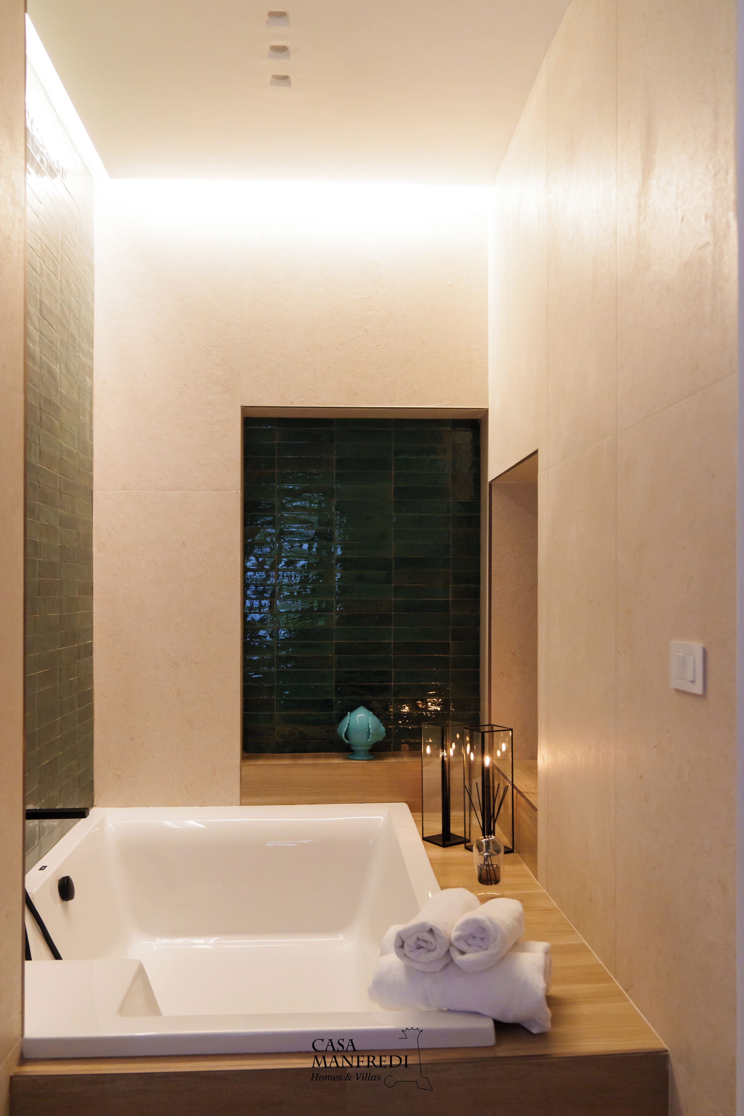 Un baño moderno con una bañera, un tocador de madera y un espejo decorativo.