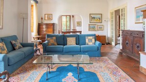 A living room with two sofas, a glass coffee table, and a patterned rug. - Wonderful apartment in Villa with nice garden and terrace. Lovely neighborhood   (Firenze)