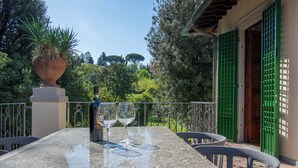 A patio with a table, two wine glasses, and a bottle of wine. - Wonderful apartment in Villa with nice garden and terrace. Lovely neighborhood   (Firenze)