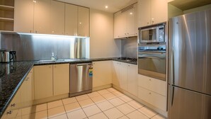 A modern kitchen with stainless steel appliances, including a dishwasher, oven, and refrigerator. - Elegant 4B 2B Unit in Melbourne CBD w/ Parking! (Melbourne)