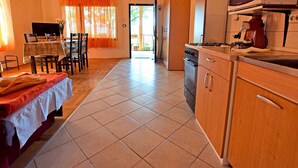 Cocina con comedor, televisión y cama.