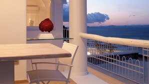 A balcony with a view of the sea, a white chair, a glass table, and a red sculpture. - Villa Fortuna by MyVillaCollection (Capri)