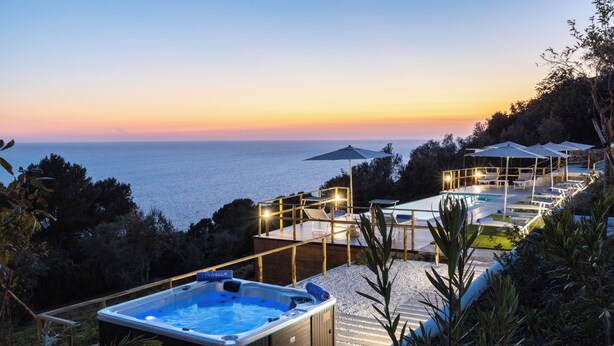 A hot tub and outdoor seating area with a view of the sea at sunset. - Villa Maiuri by MyVillaCollection (Anacapri)