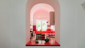 A kitchen with red and white color scheme, a window, and a neon sign that reads "bar à vin". - Villa Maiuri by MyVillaCollection (Anacapri)