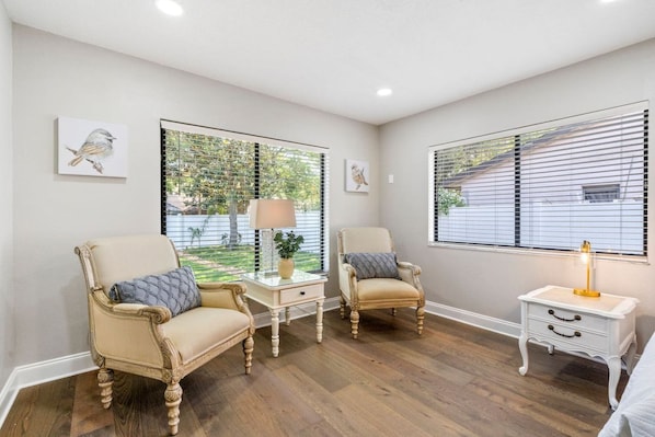 A room with two armchairs, a small table with a lamp, and a nightstand. - Florida Haven 4/2.5 Vacation Ready Home! Book Now! (Seminole)