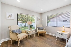Une pièce comprenant deux fauteuils, une petite table avec une lampe et une table de chevet.