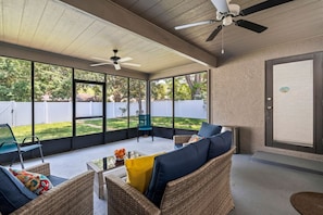 A covered patio area with wicker furniture, a ceiling fan, and a view of the backyard. - Florida Haven 4/2.5 Vacation Ready Home! Book Now! (Seminole)