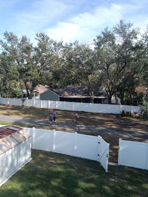A residential street with a white fence, houses, and trees. - Florida Haven 4/2.5 Vacation Ready Home! Book Now! (Seminole)