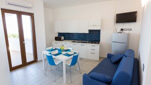 A compact living space with a kitchenette, a dining area, and a sofa.