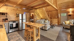 Een gezellig houten blokhutinterieur met keuken, eethoek en zithoek.