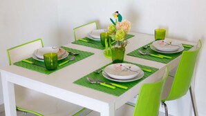 A dining table set with green placemats, white plates, and green chairs. - Orizzonte Blu Deluxe 13 A, Palinuro, Cilento (Palinuro)