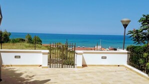 A view of the sea from a gated patio with a lamp post and a white wall. - Orizzonte Blu Deluxe 13 A, Palinuro, Cilento (Palinuro)
