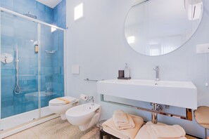 A modern bathroom with a glass shower enclosure, a white sink, and a round mirror. - B&B Fontanella32  (Porto Sant'Elpidio)