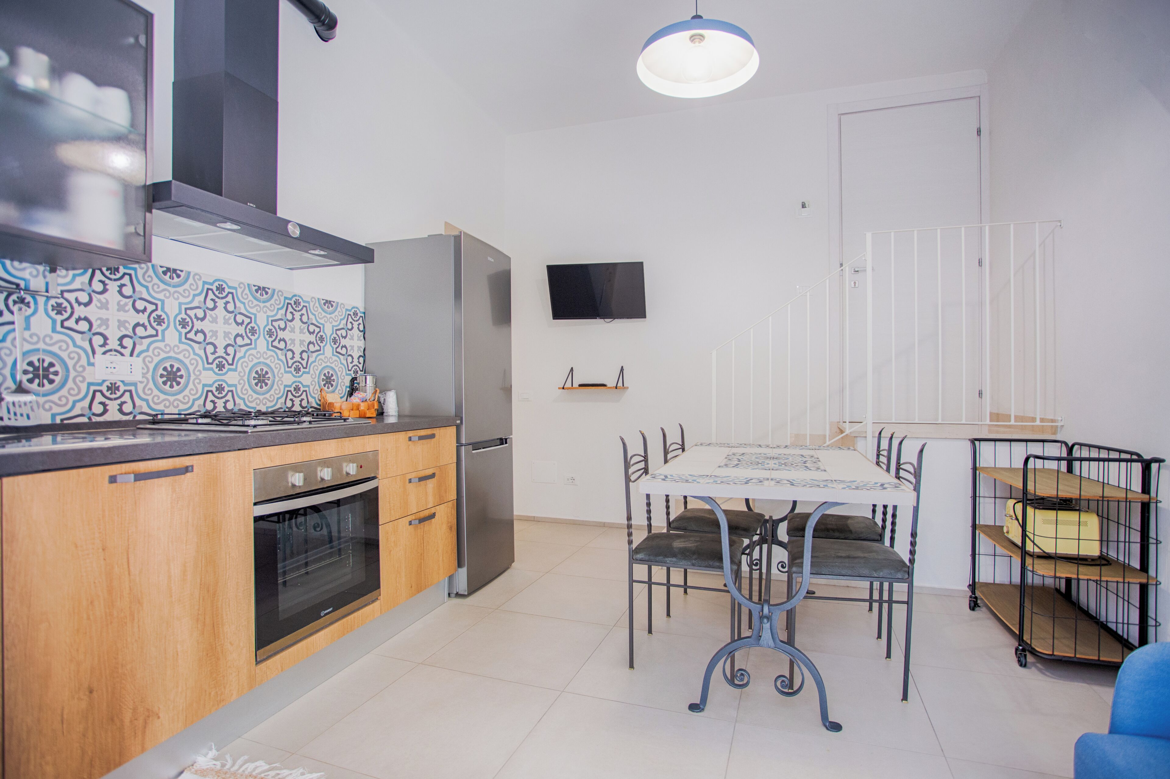 Una cocina moderna con armarios de madera, horno empotrado y refrigerador de acero inoxidable.