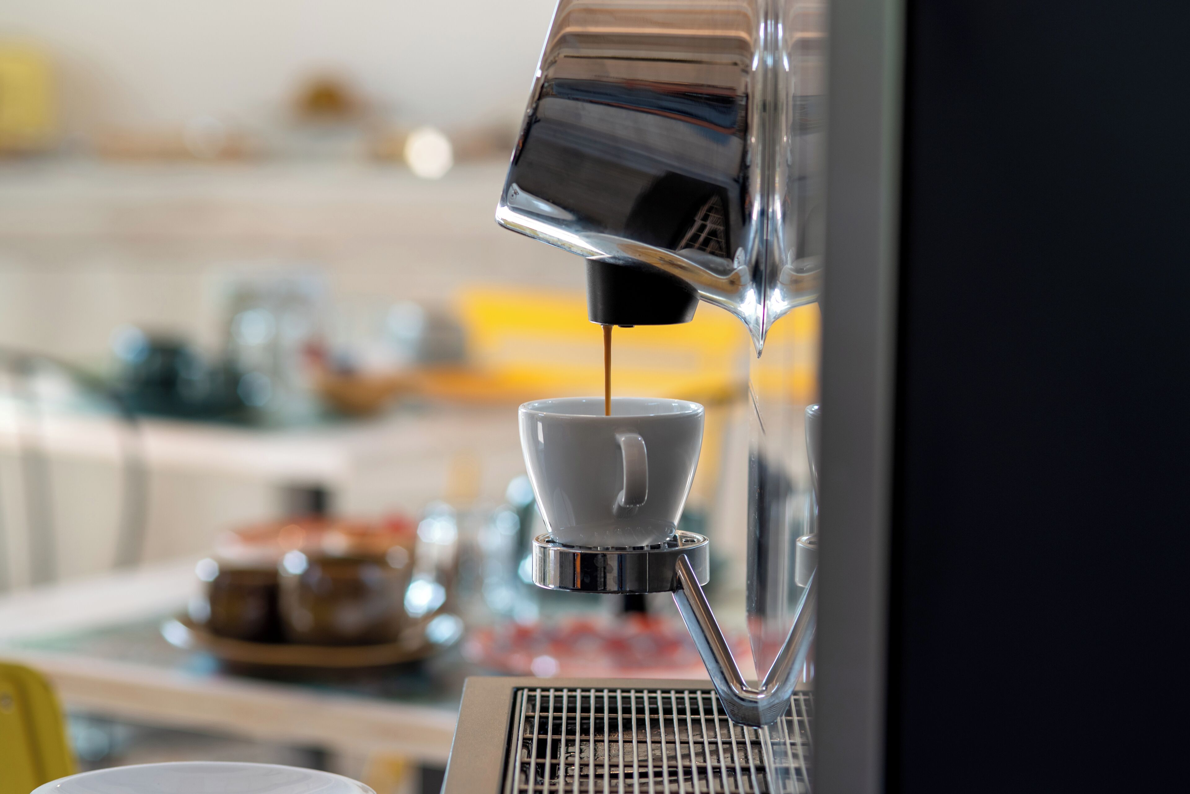 Una máquina de café sirviendo espresso en una taza.