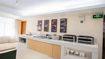 A modern kitchen with a central island, built-in appliances, and a coffee station.
