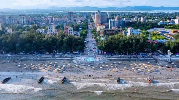 Un paysage urbain côtier avec un boulevard central, une plage et des bâtiments environnants.