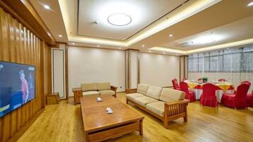 Un salón amplio con una mesa de centro de madera, sofás y un televisor.